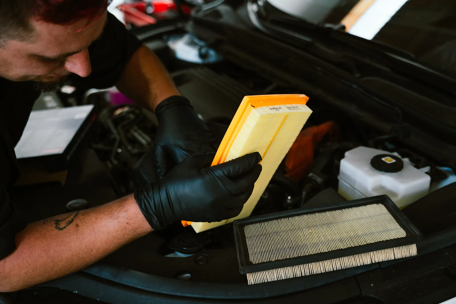 Mechanic replacing an engine air filter during a tune-up service in Escondido